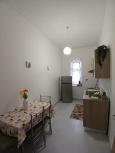 a living room with a table and a kitchen at Victoria Home in Eboli