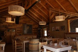 a dining room with tables and chairs and pendant lights at Los Molles Complejo Turistico in Los Molles