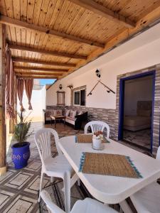 eine Terrasse mit einem weißen Tisch und Stühlen in der Unterkunft Studio pêcheur in Oualidia
