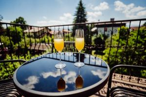 two glasses of wine on a table on a balcony at Willa Berg Cieplice in Jelenia Góra