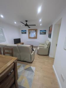 a living room with two couches and a ceiling fan at 6 bedroom house Trochetia in Crawley