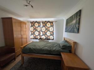 a bedroom with a bed and a window with a curtain at 6 bedroom house Trochetia in Crawley