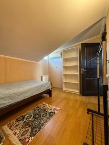 a bedroom with a bed and a rug on a wooden floor at Home in Mtskheta in Mtskheta +5 photos