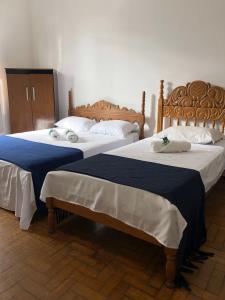two beds sitting next to each other in a room at Pousada Barão Real in São Lourenço +69 photos