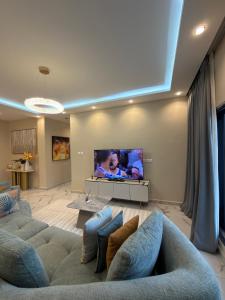 a living room with a couch and a flat screen tv at Bellagio Two Bedroom with Balcony in Kwedonu