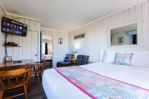a bedroom with a bed and a desk and a table at Tillicum Beach Motel - Formerly Deane's Oceanfront Lodge in Yachats