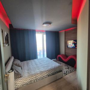 a bedroom with a bed in a room with red lights at Dana Residence in Floreşti