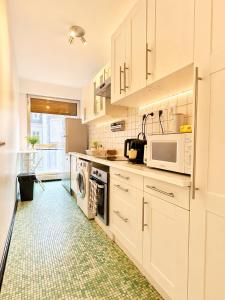 a kitchen with white cabinets and a green floor at Champs elysees apartment 4 in Paris