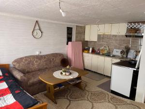 a living room with a couch and a table and a kitchen at Prokoško jezero Zlatna koliba in Fojnica +53 photos