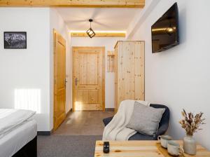 a bedroom with a bed and a couch and a table at Villa Taternik - Studio Apartment - Mountain View in Zakopane