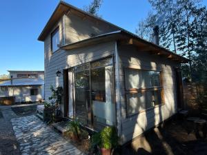 a tiny house with glass doors in a yard at Cabaña en Buchupureo in Tiuquilemu