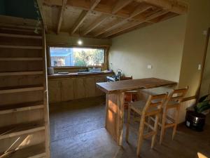 a kitchen with a counter and a table and chairs at Cabaña en Buchupureo in Tiuquilemu +11 photos