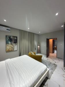 a bedroom with a large white bed and a chair at Bellagio Two Bedroom with Balcony in Kwedonu