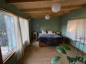 a bedroom with a bed and a large window at Cabaña en Buchupureo in Tiuquilemu