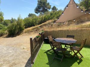 a table and chairs with an umbrella on the grass at Le Cocon de Réals in Murviel +7 photos