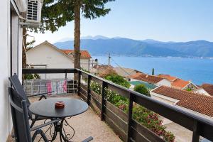 a balcony with a table and a view of the water at Villa Bellevue Amazing Sea View 7 Guests in Krašići