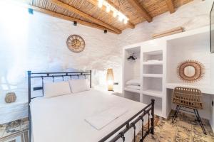 a bedroom with a bed and a chair in a room at Aloni Houses Kythnos in Loutra
