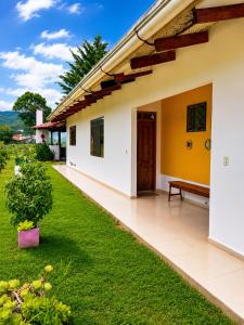 a house with a green lawn in front of it at Looking Samaipata Habitación Doble in Samaipata