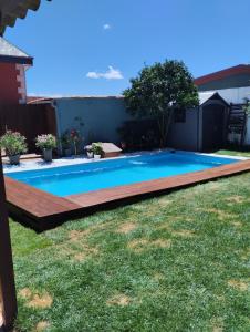 a swimming pool with a wooden deck around it at Casa Alicia in Poio