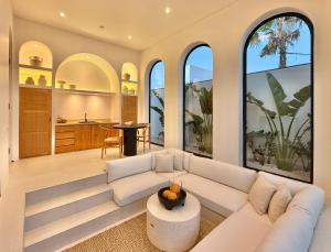 a living room with a white couch and large windows at The Young Villas - 1 Bedroom Villas, Bingin in Uluwatu