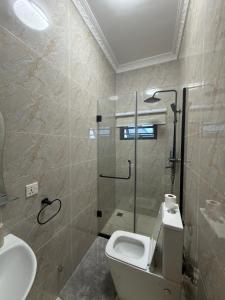 a bathroom with a shower and a toilet and a sink at Bellagio Two Bedroom with Balcony in Kwedonu +18 photos