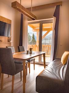 a dining room with a table and a balcony at Sylpaulerhof Aparthotel in Sankt Michael im Lungau