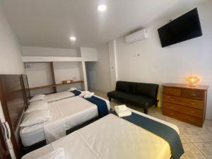 a hotel room with two beds and a flat screen tv at Costa Beach in Zorritos