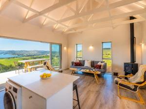 a kitchen and living room with a large window at Overview - Stay Waiheke in Ostend