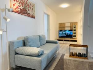 a living room with a blue couch and a tv at Altstadt Loft - Im Herzen der Altstadt - TREVIET in Pirna