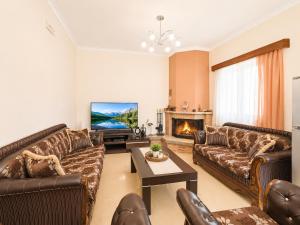 a living room with leather couches and a tv at Countryside Villa in Vlorë