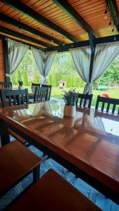 a wooden table with chairs and a potted plant on it at Serbeca in Broşteni