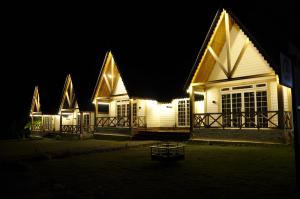 ein Haus, das nachts mit Lichtern beleuchtet ist in der Unterkunft CEDARS Resorts - Doodhpathri Kashmir in Rengazabal