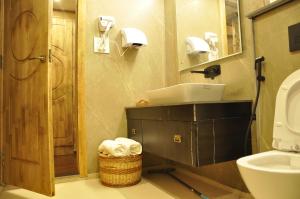 ein Badezimmer mit Waschbecken, Toilette und einem Wäschekorb in der Unterkunft CEDARS Resorts - Doodhpathri Kashmir in Rengazabal