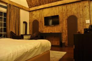 ein Hotelzimmer mit Bett und Flachbildfernseher in der Unterkunft CEDARS Resorts - Doodhpathri Kashmir in Rengazabal + 21 Fotos