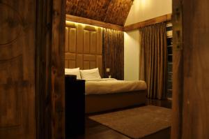 ein Schlafzimmer mit einem Bett mit hölzernem Kopfteil in der Unterkunft CEDARS Resorts - Doodhpathri Kashmir in Rengazabal