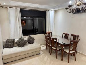 a dining room with a table and a couch at Calma in Beni Mellal