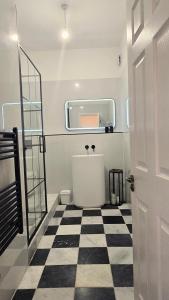 a bathroom with a tub and a checkered floor at Palace View Apartment in Buxton +21 photos