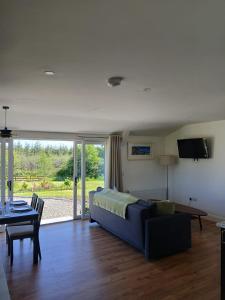 a living room with a blue couch and a table at Meadow Suite in Lahinch