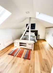 a attic bedroom with a bed and a rug at KeschtaLoft - Gîte classé 4 étoiles in Châtenois