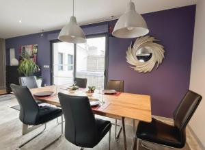 a dining room with purple walls and a wooden table and chairs at KeschtaLoft - Gîte classé 4 étoiles in Châtenois