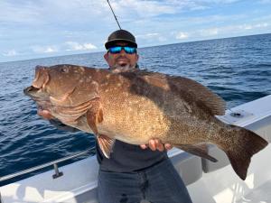 a man holding a large fish on a boat at Hotel Luna Loreto in Loreto