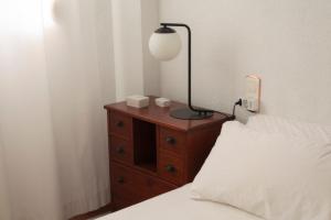 a bedroom with a bed and a lamp on a dresser at Comfortable and Elegant Seafront Apartment in Faro de Cullera