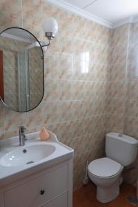 a bathroom with a sink and a toilet and a mirror at Comfortable and Elegant Seafront Apartment in Faro de Cullera +16 photos