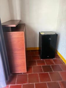 a microwave sitting on the floor next to a brick floor at Hostal Casa Horizonte in Taganga