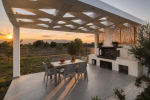 a patio with a table and chairs and a fireplace at Lion Exclusive Villa in Sarakinádhon