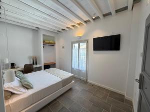 a bedroom with a bed and a tv on the wall at Myrto Hotel in Kamares