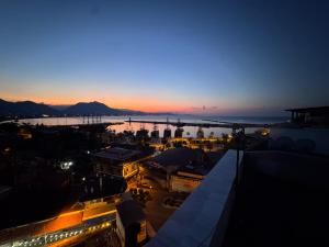 a view of a city at night with a sunset at Temiz Hotel in Alanya