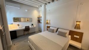a bedroom with a bed and a desk and a television at Myrto Hotel in Kamares