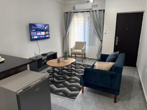 a living room with a blue couch and a table at WN Apartments in Lusaka