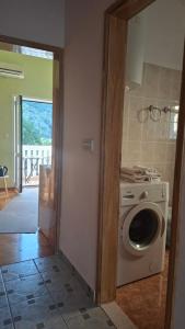 a kitchen with a washing machine in a room at Lorena Rooms in Risan